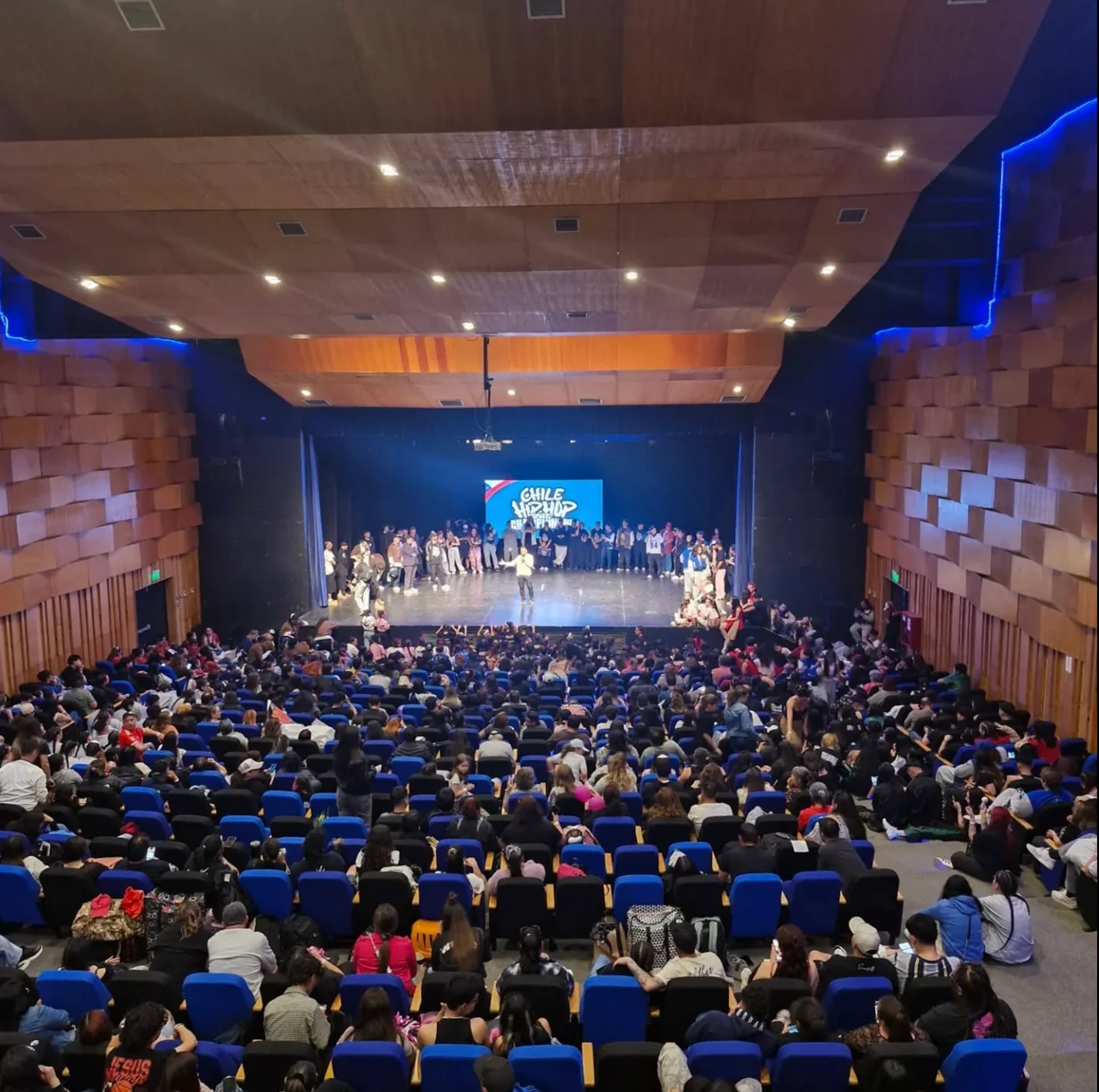 Auditorio con público y participantes reunidos sobre el escenario